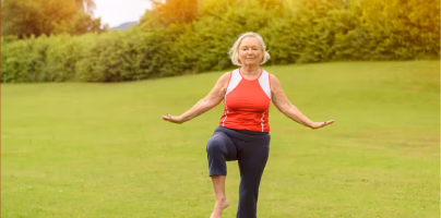 Older woman exercising outdoors on a grassy field, smiling while balancing on one leg, with the headline “You know about lifespan, but do you care about ‘healthspan?’ Here is why you should” and source label Nifty 50+.