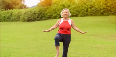Older woman exercising outdoors on a grassy field, smiling while balancing on one leg, with the headline “You know about lifespan, but do you care about ‘healthspan?’ Here is why you should” and source label Nifty 50+.